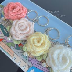 three different colored flowers are on a keychain