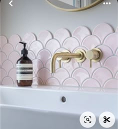 a bathroom sink with a soap dispenser next to it and a mirror on the wall