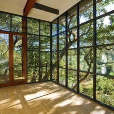 an empty room with wood floors and large windows