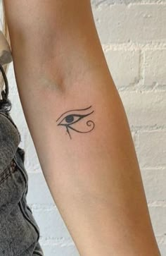 a woman's arm with an eye tattoo on the left side of her arm