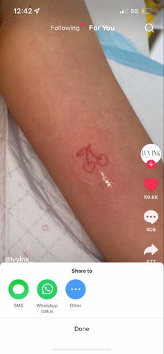 the tattoo on someone's arm is red and has an arrow drawn on it