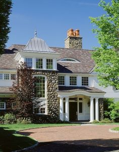 a large white house with two chimneys on top of it's roof and windows