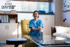 a woman in scrubs sitting at a glass table