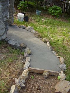 a cement walkway in the middle of a yard