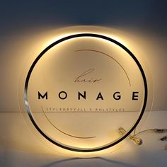 there is a neon sign with the word monograme on it in front of a white wall