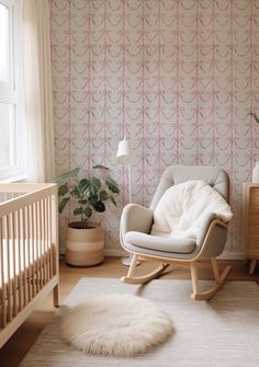 a baby's room with a rocking chair, crib and rug on the floor