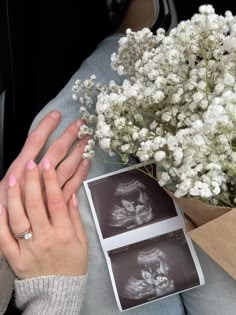 a woman's hands resting on her chest next to a bouquet of white flowers