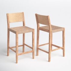 two wooden stools sitting next to each other on a white surface with no one around them