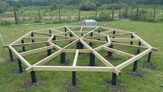 a wooden structure sitting on top of a lush green field