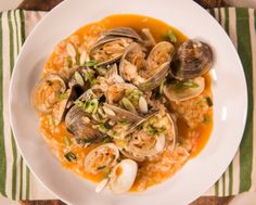 a white plate topped with clams and rice