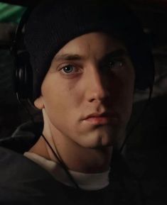 a young man wearing headphones looking at the camera