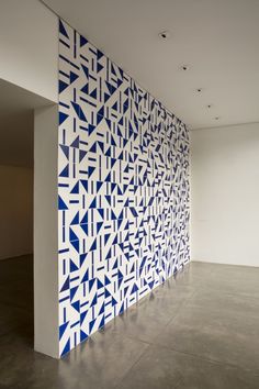 a large wall with blue and white geometric designs on it's sides in an empty room