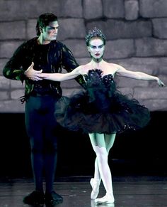 two ballerinas dressed in black and white are standing next to each other