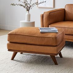 a chair and ottoman in a living room with the words west elm written on it