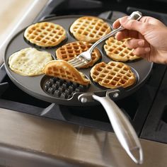 the waffles are being cooked on the stove with a spatula in hand