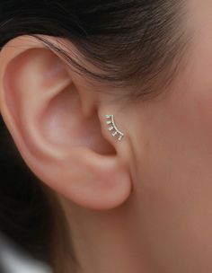 a close up of a person wearing a pair of ear piercings on their ears