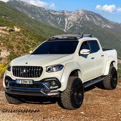 a white truck parked on top of a dirt road