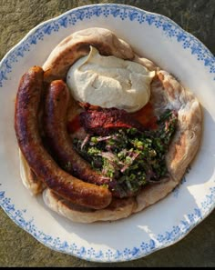 a plate with sausages, bread and butter on it sitting on top of a table