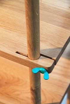 a close up of a wooden table with two blue objects on it's legs