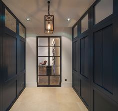 an open door leading to a living room with chairs and lamps hanging from the ceiling