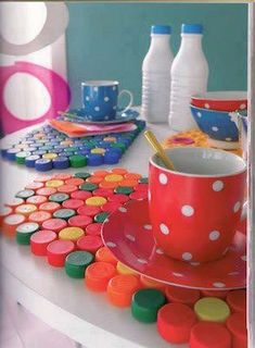 a table topped with cups and saucers covered in polka dot paint chips next to milk bottles