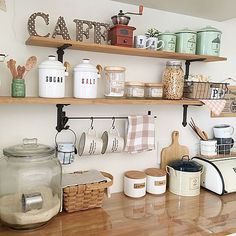 the kitchen counter has many jars and containers on it, along with utensils