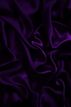 an image of a purple background that looks like silk or satin fabric with very soft folds