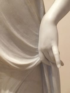 a close up of a person's hand on the back of a white statue