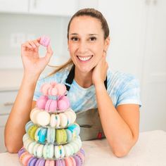 a woman sitting at a table with a stack of macaroni and cheese rings