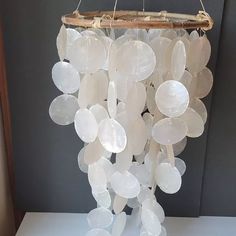 a wind chime made out of plastic discs hanging from a bamboo holder on a table