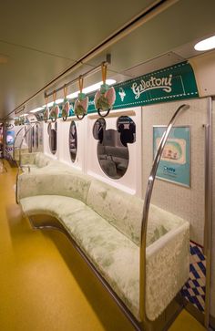 a long bench sitting next to a wall with mickey mouse signs on it's sides