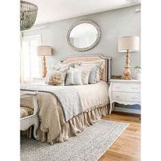 a bedroom with a bed, dresser and mirror on the wall next to a window