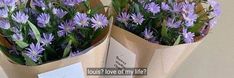 two bouquets of purple flowers are wrapped in brown paper and placed on a table