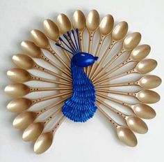 a blue and gold peacock brooch sitting on top of a white wall