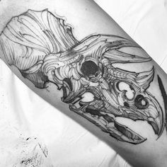 a black and white photo of a skull tattoo on the arm