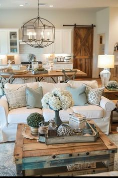 a living room filled with lots of furniture and flowers on top of a coffee table