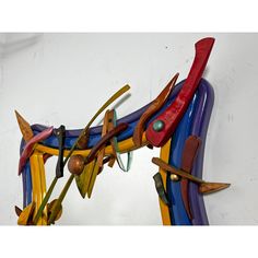 a colorful horse sculpture is hanging on the wall