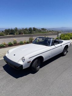 a white car is parked on the side of the road