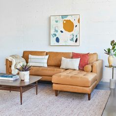 a living room filled with furniture and a painting on the wall above it's couch