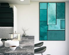 an abstract painting is hanging on the wall above a kitchen counter with chairs and plates