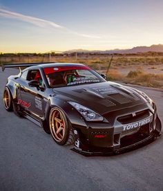 a black sports car driving down the road