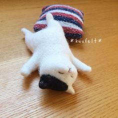 a stuffed animal laying on top of a wooden table