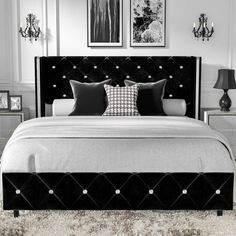 a black and white photo of a bedroom with chandelier above the headboard