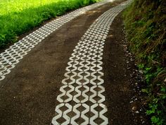 an image of a road that is painted with white paint and grass in the background