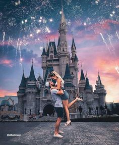 a man and woman dancing in front of a castle with fireworks coming out of it