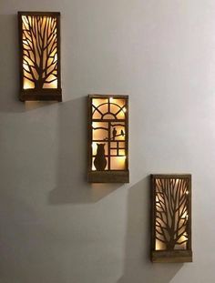 three decorative wall lights on the side of a white wall with trees and birds in them