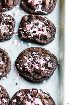 chocolate peppermint cookies on a baking sheet with sprinkles and crushed candy