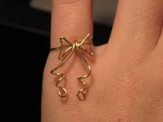 a woman's hand with a ring on it that is shaped like a musical note