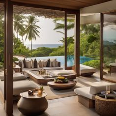 a living room filled with lots of furniture next to a large window overlooking the ocean