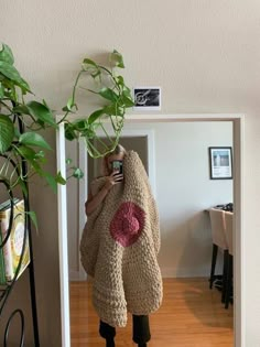 a woman taking a selfie with her cell phone while wrapped in a teddy bear blanket